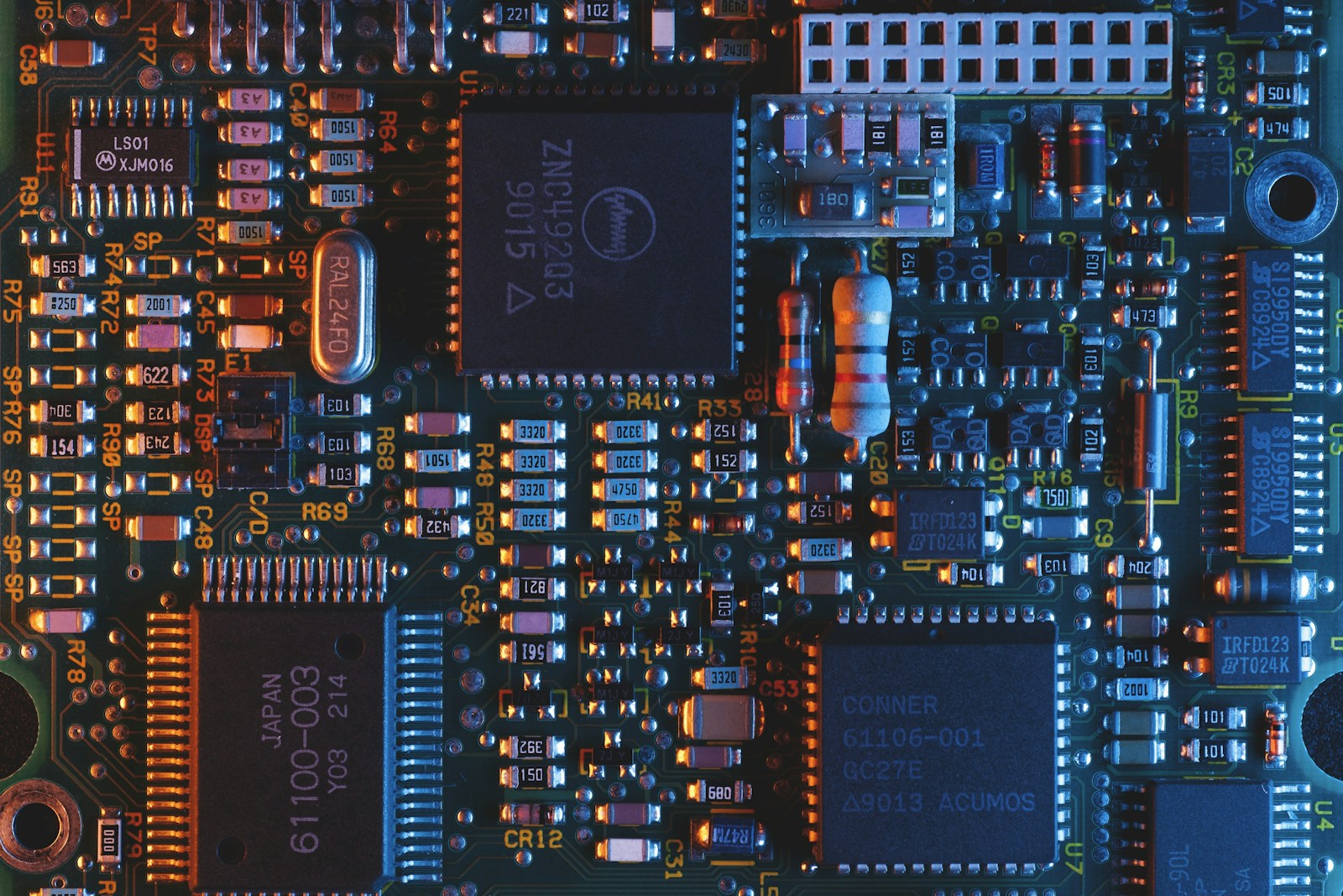 Macro photograph of a real populated circuit board with ICs, passives, and solder joints